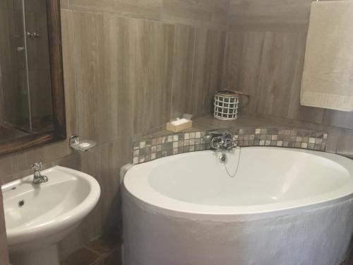 a bathroom with a white tub and a sink at Windmills Rest in Pretoria