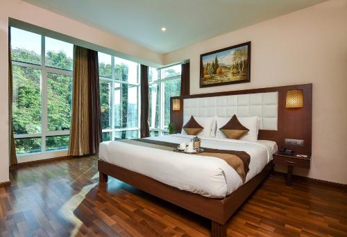 a large bedroom with a large bed with windows at Akshaya Aura in Bangalore