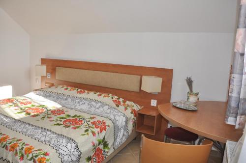 a bedroom with a bed and a table with a table at Pensiune Muzeu Traditional Poveste in Transilvania in Sighişoara