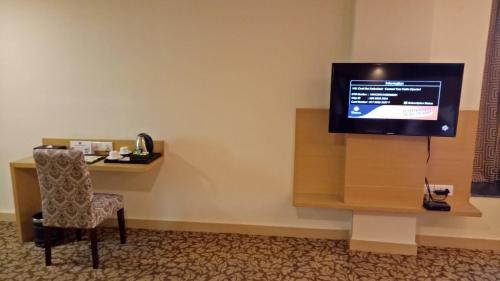 a room with a desk and a television on a wall at Hotel Patliputra Continental in Patna