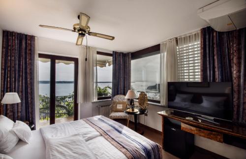 Villa Bellevue Portoroz-Portorose في بوروتوروج: غرفة نوم بسرير وتلفزيون بشاشة مسطحة