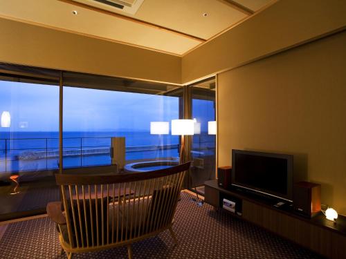 a living room with a television and a large window at Amahara in Sumoto