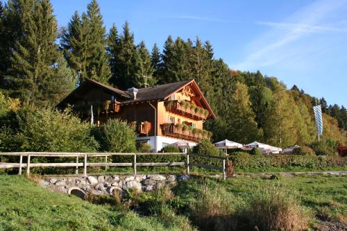 a house on a hill with a fence at Cafe Maria - Pension - B&B in Rieden am Forggensee