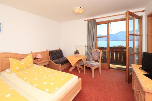 a bedroom with a bed and a couch and a television at Cafe Maria - Pension - B&B in Rieden am Forggensee