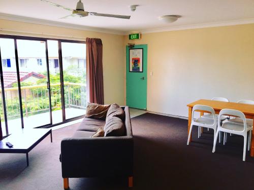 a living room with a couch and a table at Maxmee Backpackers Resort in Gold Coast