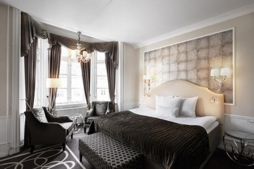 um quarto de hotel com uma cama e uma cadeira em Phoenix Copenhagen em Copenhague