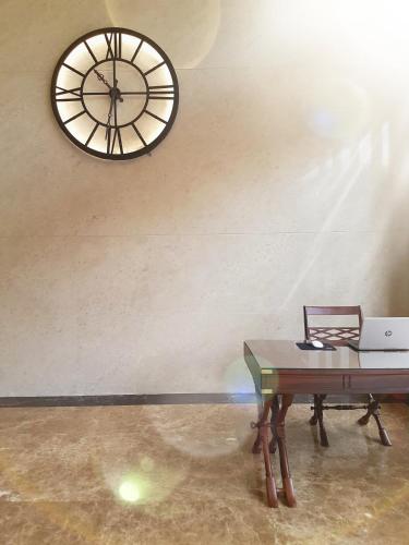 a clock hanging on a wall next to a table at Manhattan Business Hotel TTDI in Petaling Jaya