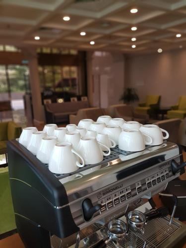 een groep witte kopjes op een koffiezetapparaat bij Manhattan Business Hotel TTDI in Petaling Jaya