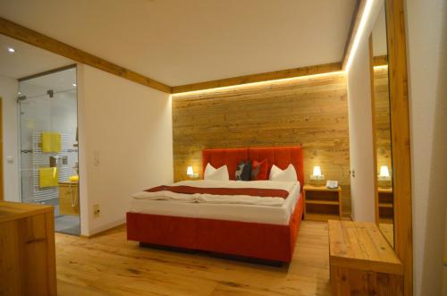 um quarto com uma cama e uma parede de madeira em Hotel Sonnalp em Kirchberg in Tirol