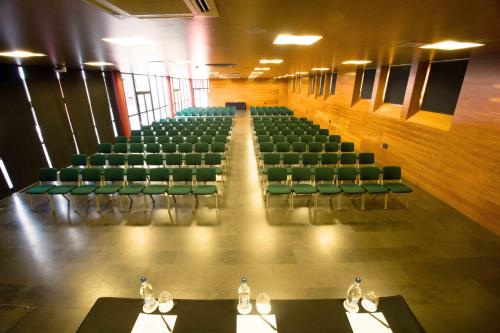 an empty auditorium with green chairs and tables at Hotel Escuela Santa Cruz in Santa Cruz de Tenerife