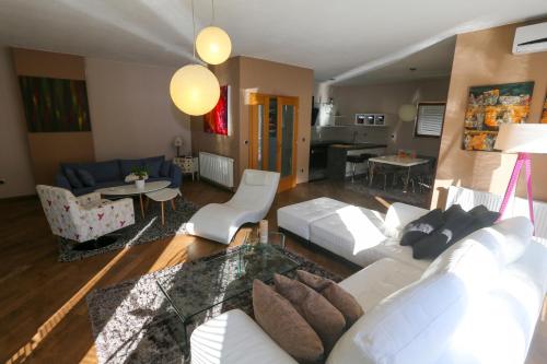 a living room with a white couch and a table at Farah Superior Apartments in Bihać