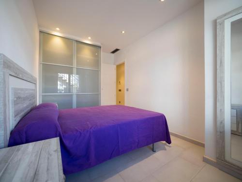 1 dormitorio con cama morada y ventana en InmoSantos Oasis E2, en Roses
