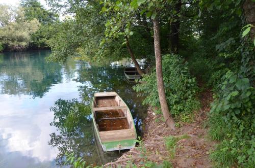 an old boat sitting on the side of a river at Farah Superior Apartments in Bihać