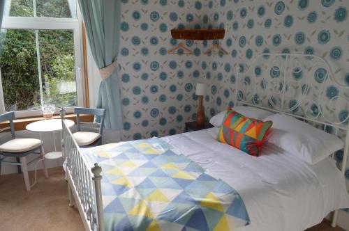 1 dormitorio con cama, mesa y ventana en Briar Brae Bed & Breakfast en Stranraer