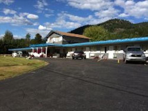 a building with cars parked in a parking lot at Evening Star Motel in Greenwood