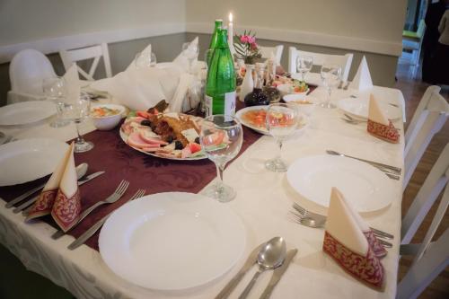 a table with white plates and wine glasses on it at Hotel Merkur in Miercurea-Ciuc