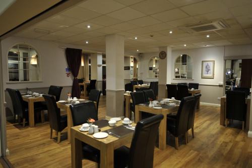 um restaurante com mesas e cadeiras num quarto em Oliver Cromwell Hotel em March