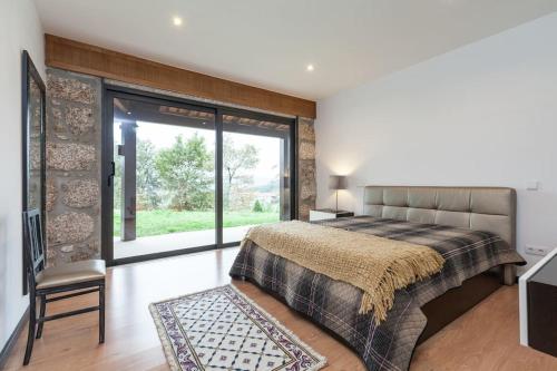 a bedroom with a bed and a large window at Casa dos Colados in Fafe