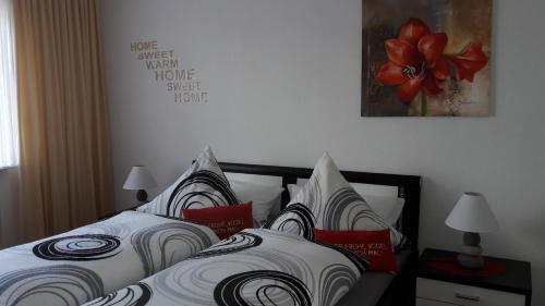 Schlafzimmer mit einem Bett mit weißen und roten Kissen in der Unterkunft Ferienwohnung Zur Stollenlinde in Goslar