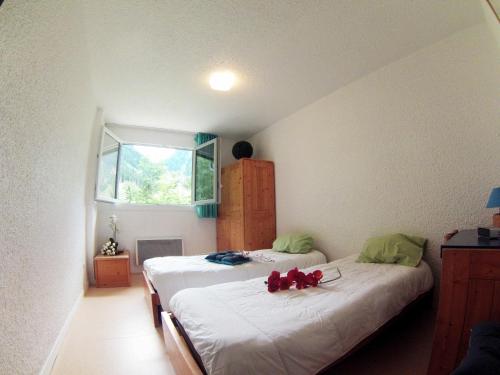 deux lits jumeaux dans une chambre avec fenêtre dans l'établissement Village vacances du Haut-Bréda aux 7 Laux, à La Ferrière