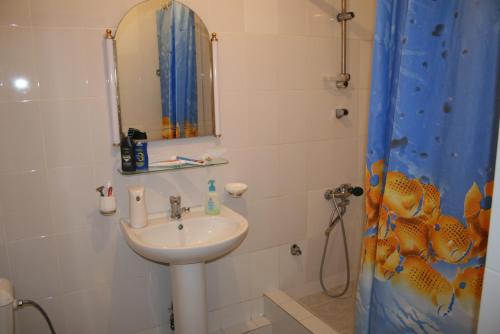 a bathroom with a sink and a mirror and a shower at Hostel Americana in Astana