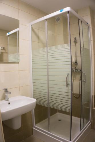 a bathroom with a shower and a sink at Hotel Merkur in Miercurea-Ciuc
