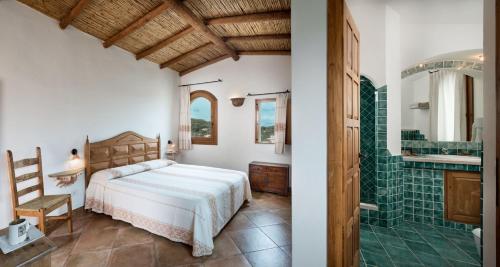 a bedroom with a bed and a bathroom with a shower at Hotel Arathena in San Pantaleo