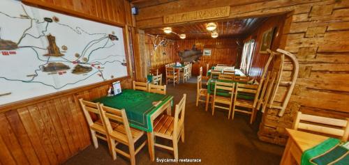 a dining room with tables and chairs in a cabin at Turistická chata Švýcarna in Loučná nad Desnou