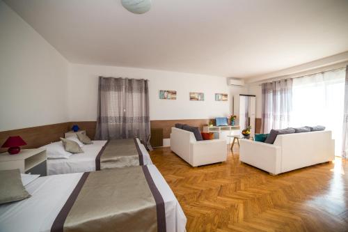 a hotel room with two beds and a living room at Holiday Home White House in Podstrana