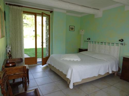 een slaapkamer met een wit bed en een raam bij Domaine De La Grange Neuve in La Roque-sur-Pernes