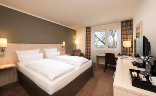 Un pat sau paturi într-o cameră la Mercure Hotel Bielefeld Johannisberg