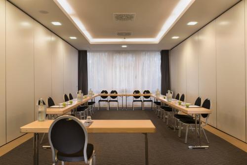 a conference room with long tables and chairs at Mercure Hotel Bielefeld Johannisberg in Bielefeld