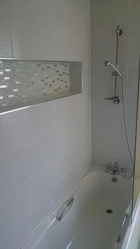 a bath tub with a shower in a bathroom at The Silverdale Hotel in Silverdale