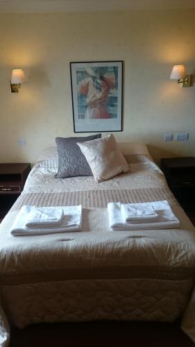 a large bed with two towels on top of it at The Silverdale Hotel in Silverdale