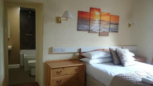 a bedroom with a bed and a bathroom with a sink at The Silverdale Hotel in Silverdale