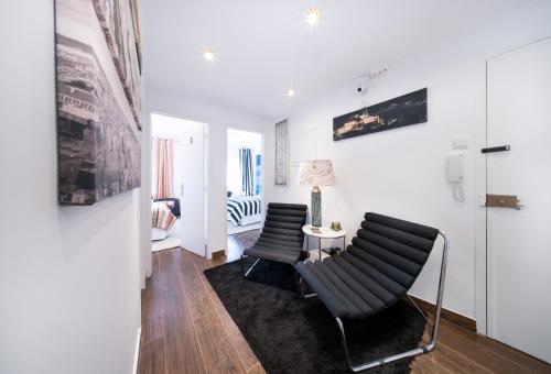 a living room with two chairs and a table at PH in Setúbal in Setúbal