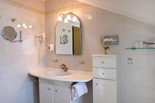 bagno con lavandino e specchio di Hotel Landhaus Fuhrgassl-Huber a Vienna