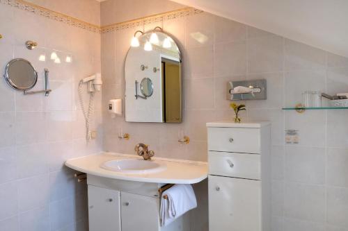a bathroom with a sink and a mirror at Hotel Landhaus Fuhrgassl-Huber in Vienna