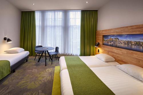 a hotel room with two beds and a table at Nova Hotel in Amsterdam
