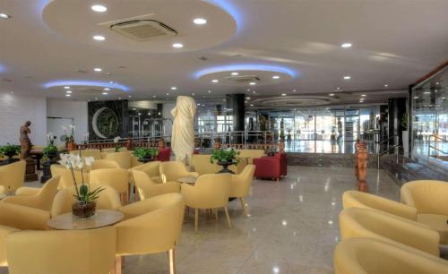 a restaurant with yellow chairs and tables in a room at Hotel & Spa Entremares in La Manga del Mar Menor