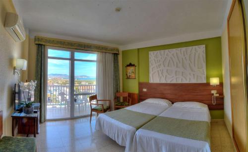 a hotel room with a bed and a balcony at Hotel & Spa Entremares in La Manga del Mar Menor
