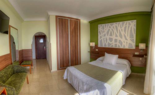 a bedroom with a bed and a green wall at Hotel & Spa Entremares in La Manga del Mar Menor