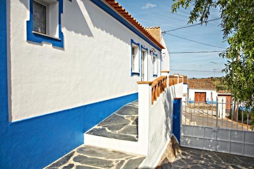 ein blau-weißes Haus mit einer Treppe in der Unterkunft Casa da Eira in Reguengos de Monsaraz