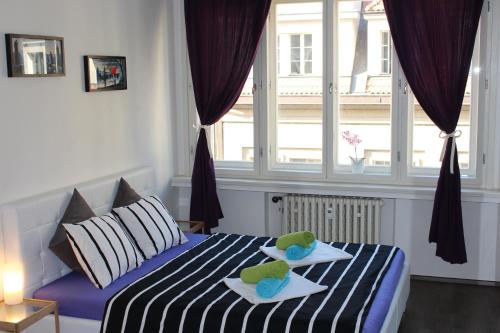 a bedroom with two towels on a bed with a window at Go Native Prague Apartment in Prague