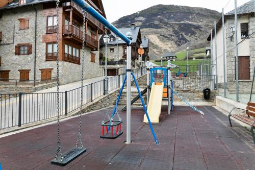 a playground with swings and a slide at Gessa Luxury Apartments - parking a pie de pistas Val de Ruda in Gessa