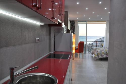 cocina con fregadero y encimera roja en Studio Sea View Terrace, en Torremolinos