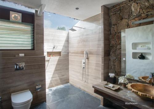 a bathroom with a shower and a toilet and a sink at The Serai Bandipur in Bandipūr
