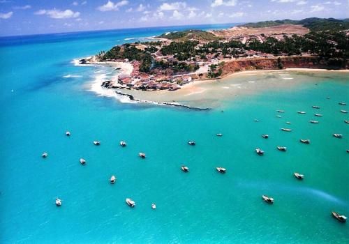 an aerial view of a beach with boats in the water at Pousada Farol Eco Adventure in Baía Formosa