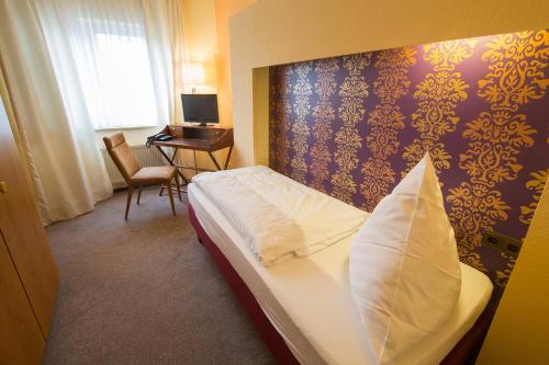 a hotel room with a bed with a pillow on it at BSW Ferienhotel Lindenbach in Bad Ems