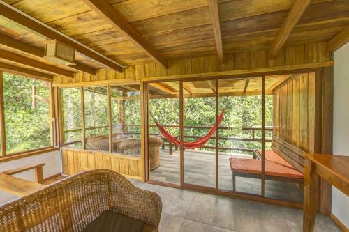 a room with a porch with a hammock in it at Terrabambu Lodge in Mindo